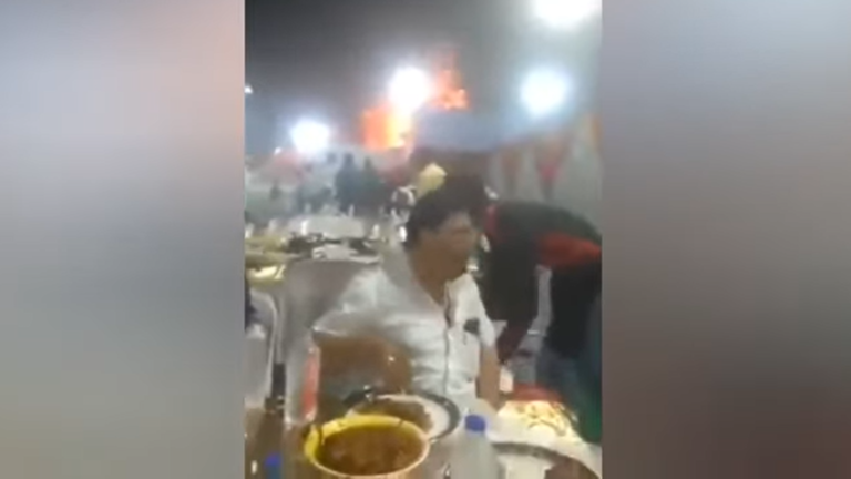 ضيفان ينشغلان بالأكل في حفل زفاف دون مبالاة بحريق هائل خلفهما (فيديو)